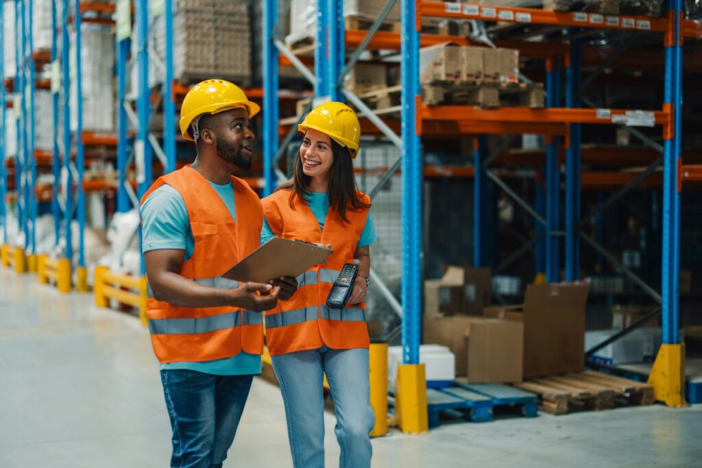 Diverse warehouse employees collaborating on inventory and logistics tasks