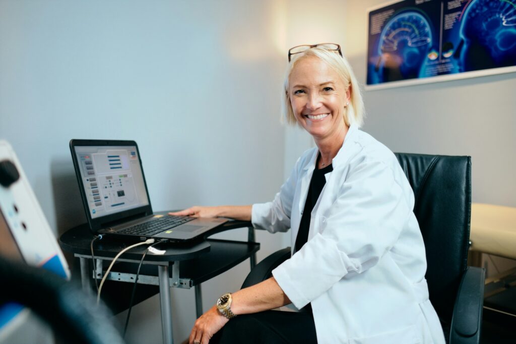 Portrait Female Doctor Working In Hospital Office With Computer Smiling