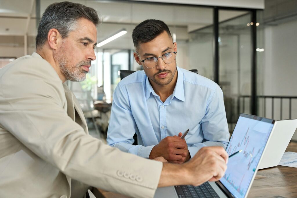 Two busy business men investors doing financial trading market data analysis.