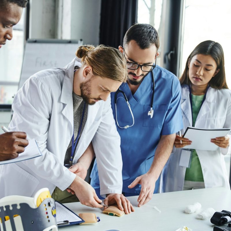 young student making injection in training pad near medical equipment, healthcare worker